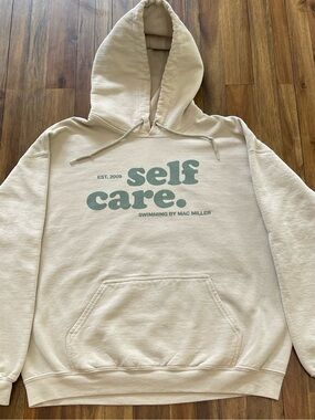 Mac Miller Self Care Gildan Cream Hoodie with Green Lettering.
